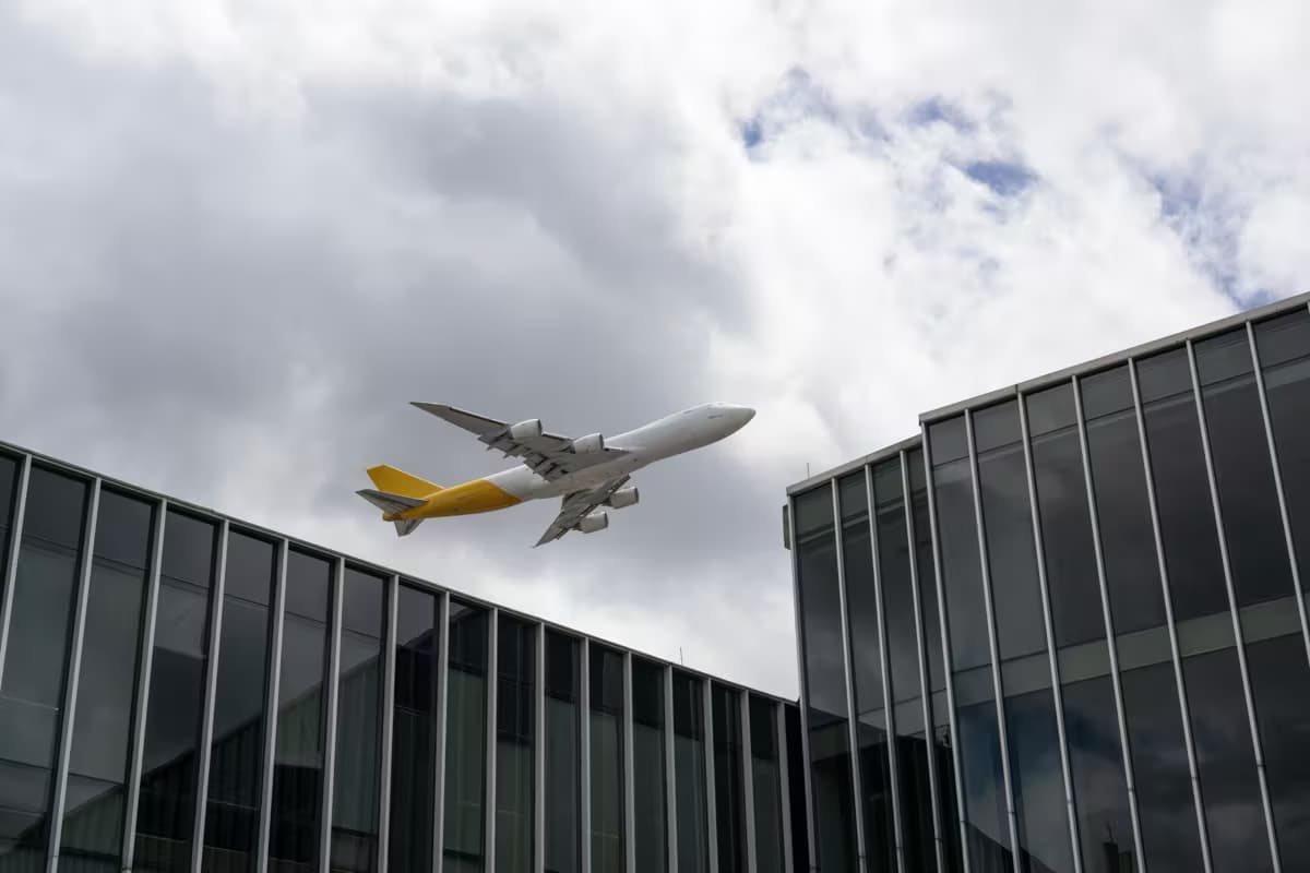 Vrachtvliegtuig dat opstijgt boven kantoorgebouwen