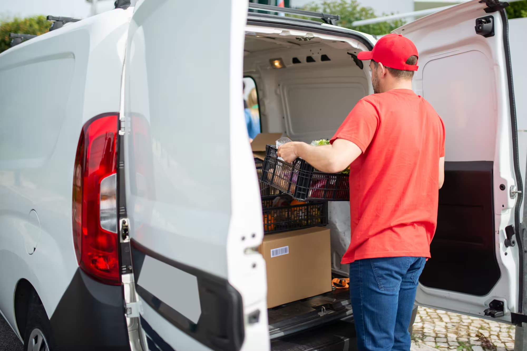 Koerier die een pakket uit een bestelwagen laadt