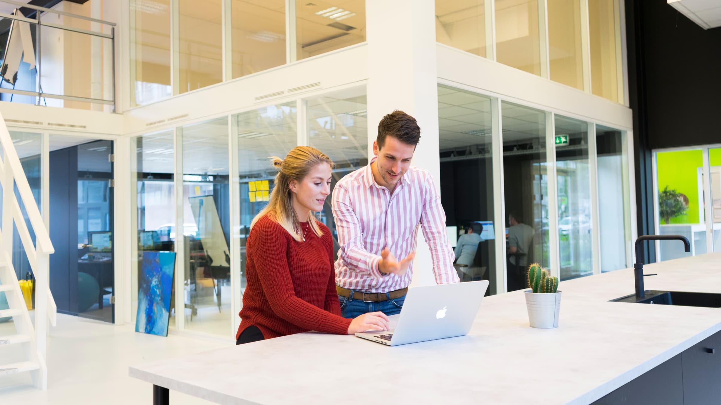Twee adviseurs bespreken fiscale keuzes op een laptop in het Finexpert-kantoor
