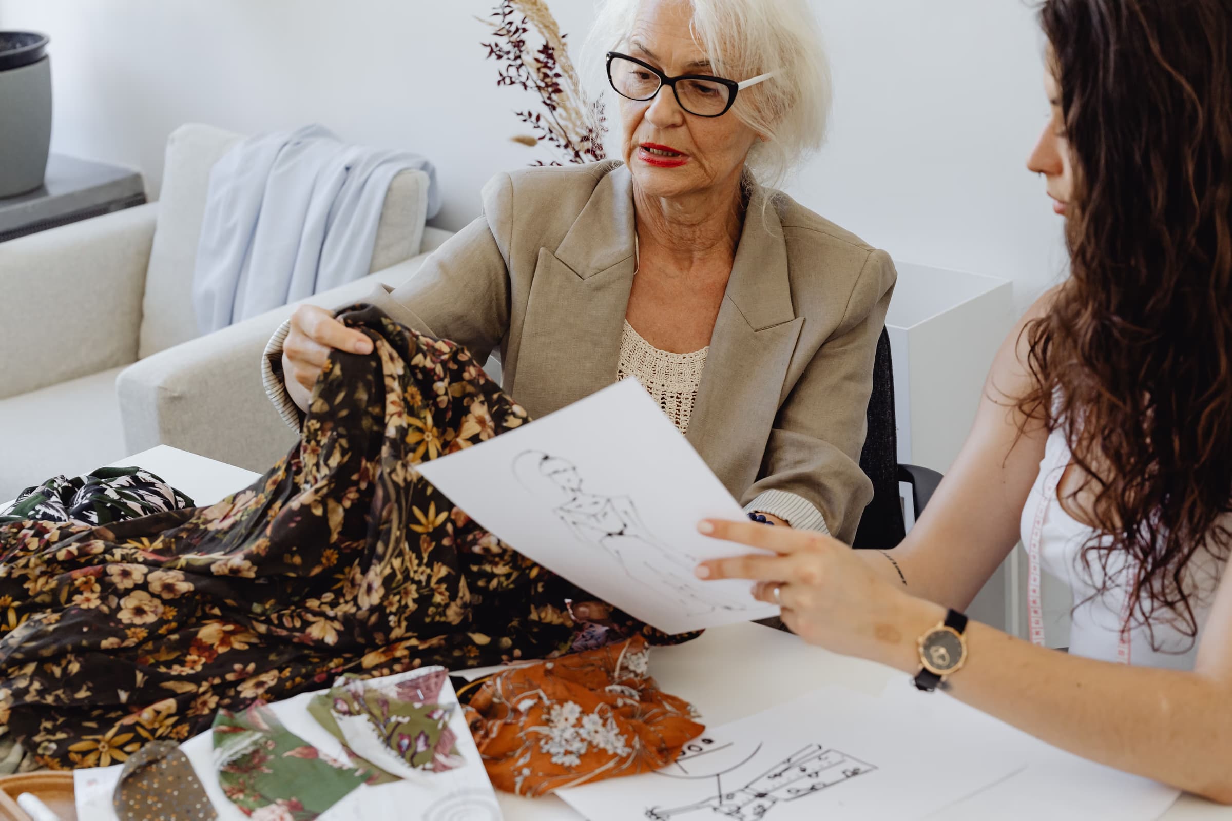 Starting fashion entrepreneur discussing her designs with an experienced mentor